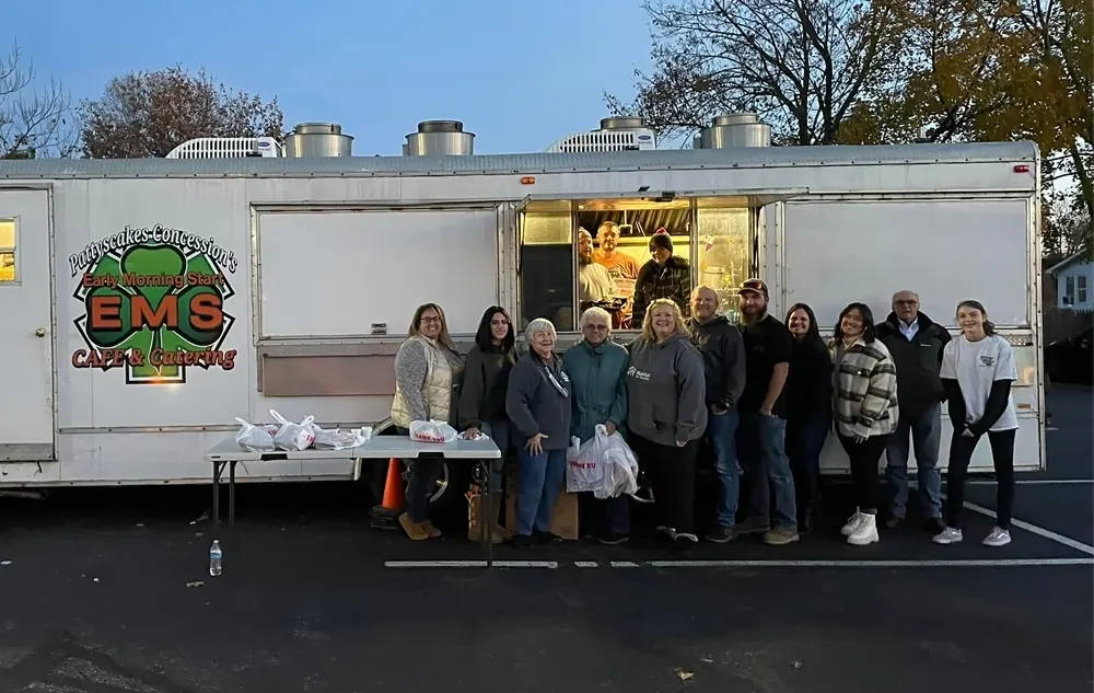 Group of our volunteers standing outside in front of food truck